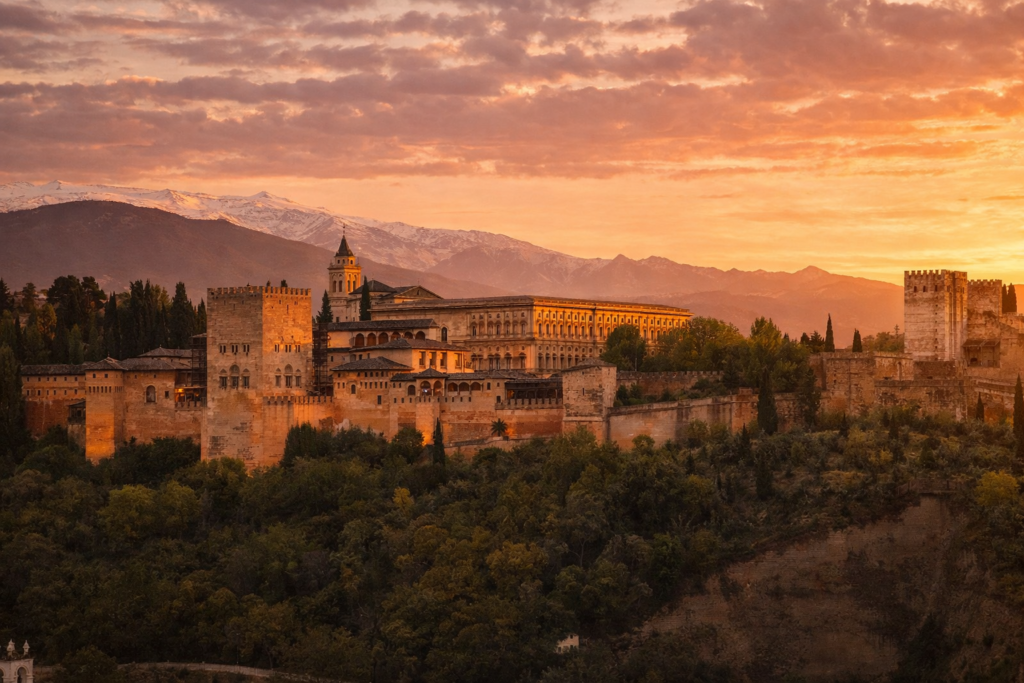 Sunset view of the Alhambra palace with snow-capped Sierra Nevada mountains from Mirador de San Nicolás viewpoint